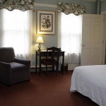 Hotel Coolidge room with king bed, desk, chair, and tv