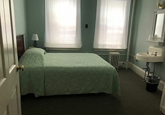 Updated-Coolidge-House-Room light blue green bed spread on bed at the Coolidge House at Hotel Coolidge